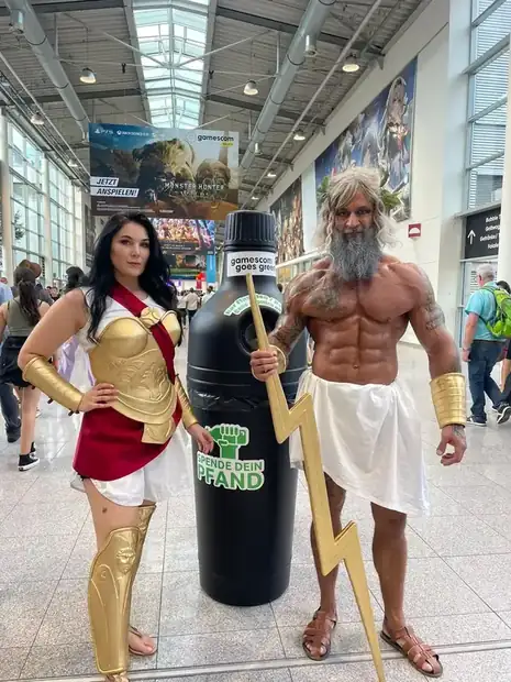 Schwarzer Pfandbehälter zwischen zwei kostümierten Besuchern auf der gamescom